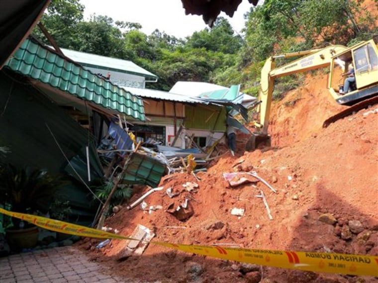 A rescuer uses a construction machine to search for the bodies believed to be buried by a landslide in Hulu Langat in central Selangor state, outside Kuala Lumpur, Malaysia, on Saturday.